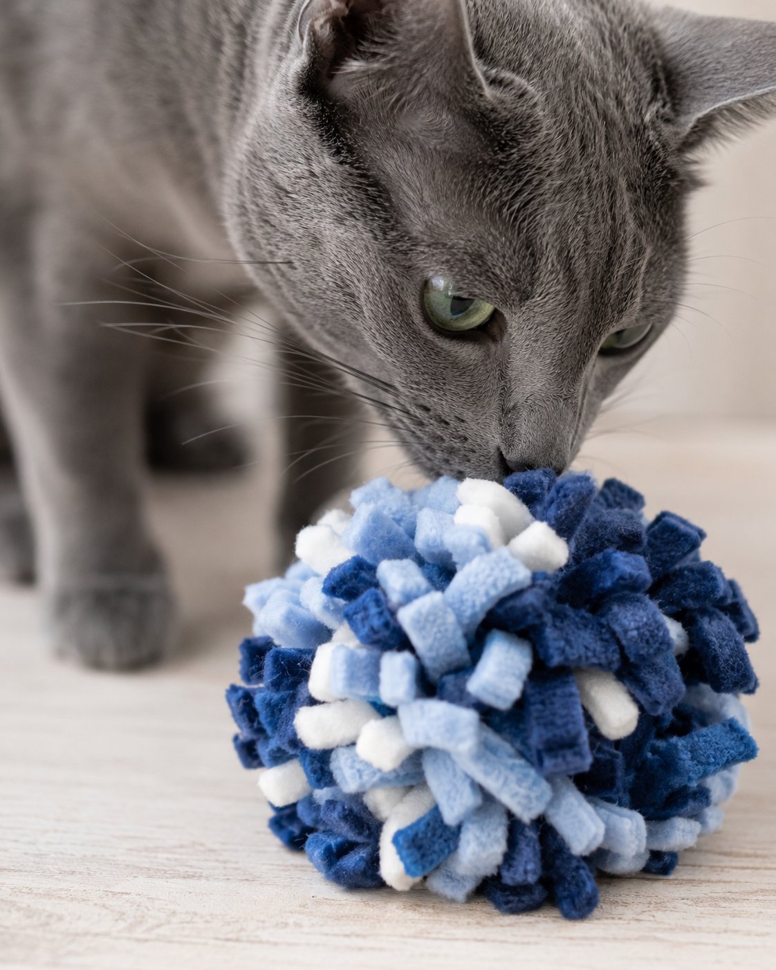 Ein selbstgemachter, flauschiger Pompon aus buntem Fleece-Stoff.